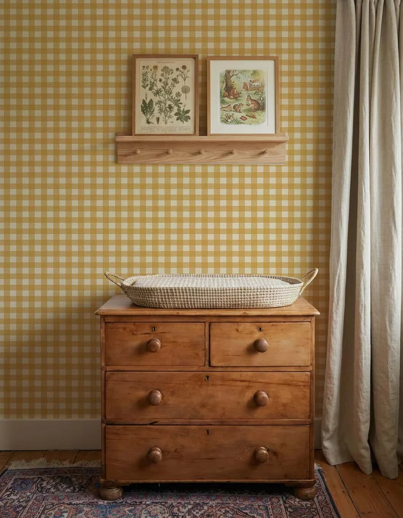 Ochre Yellow Gingham wallpaper by Atelier Chien behind a wooden changing table with a changing basket.