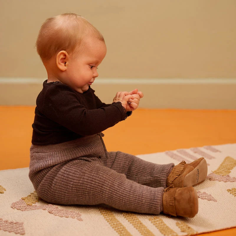 Moccasin Suede Slippers – Chaussons pour bébé en cuir avec semelle antidérapante en suède – MELTON : enfant assis portant les chaussons pour bébé.