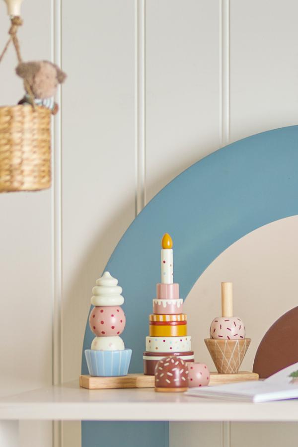 Celebrate Activity Toy – Bloomingville MINI: stapelspeelgoed op een plank in de kinderkamer.