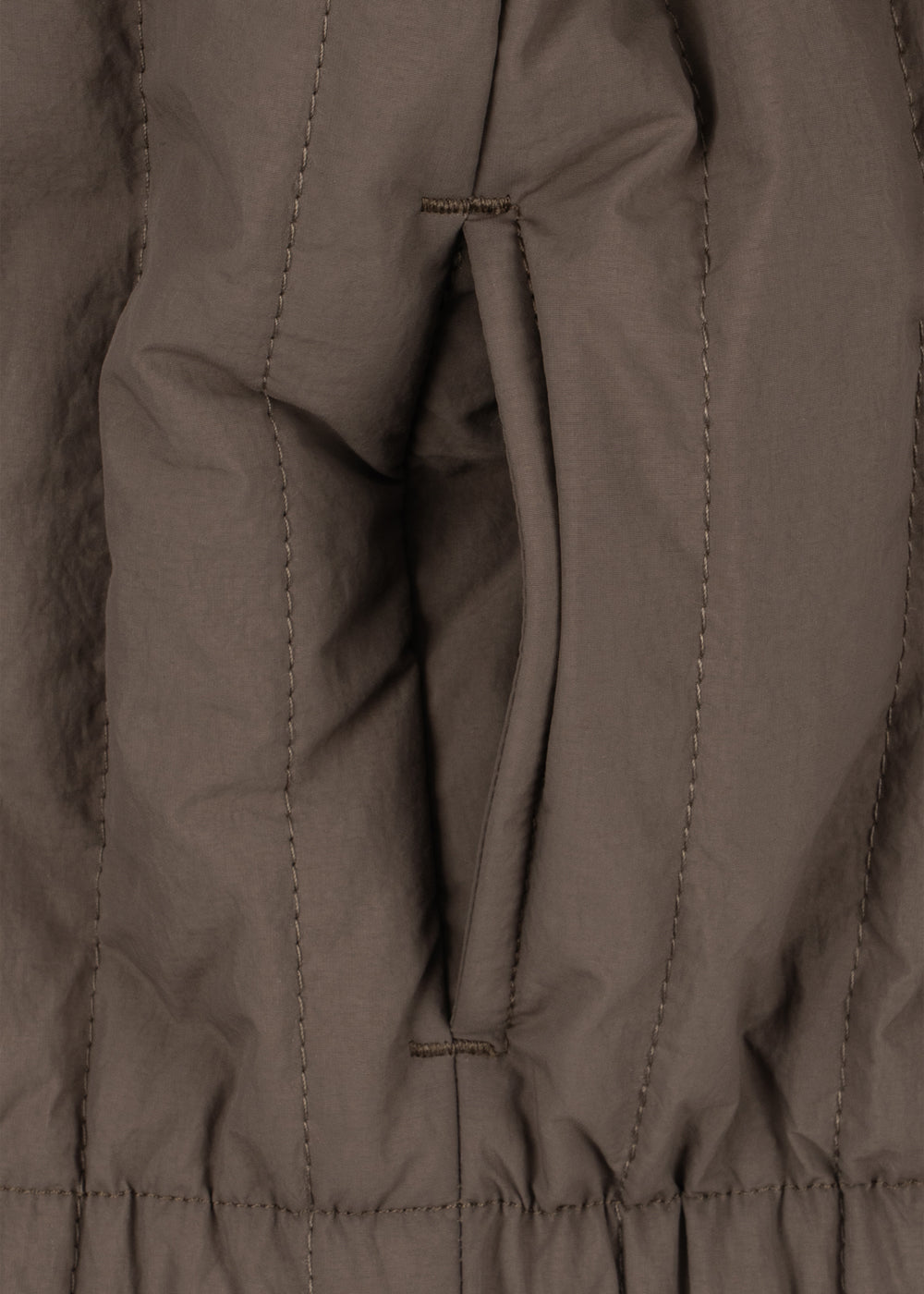 Veste thermique Juno Bomber – Walnut – Konges Sløjd : détail de l'intérieur et de la boucle de suspension de la veste.