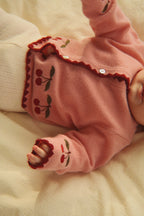 Wollen vest Collette – Pale Blush – Konges Sløjd: detail van de gedragen roze kersentrui met donkere rand.