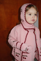 Woll-Balaclava Collette – Pale Blush – Konges Sløjd: Kind mit rosa Strickjacke und passender Kirschen-Balaclava.