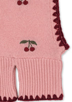 Woll-Balaclava Collette – Pale Blush – Konges Sløjd: Detail der Kirschen, des dunklen Saums und des Rippbündchens der Balaclava.